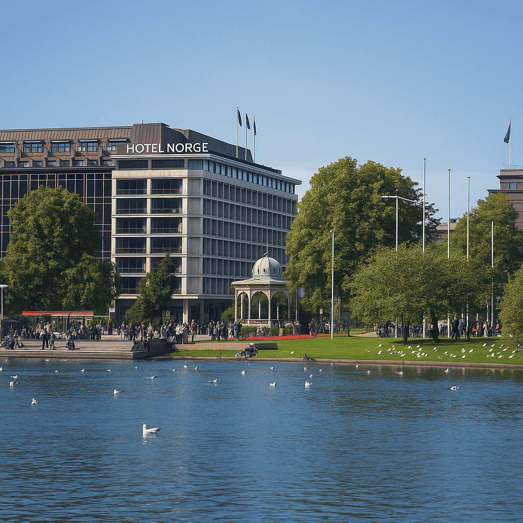 Scenic waterfront view in Oslo, Norway, featuring Hotel Norge, a modern building beside a park with lush trees, a green-roofed gazebo, and calm fjord waters with seagulls.