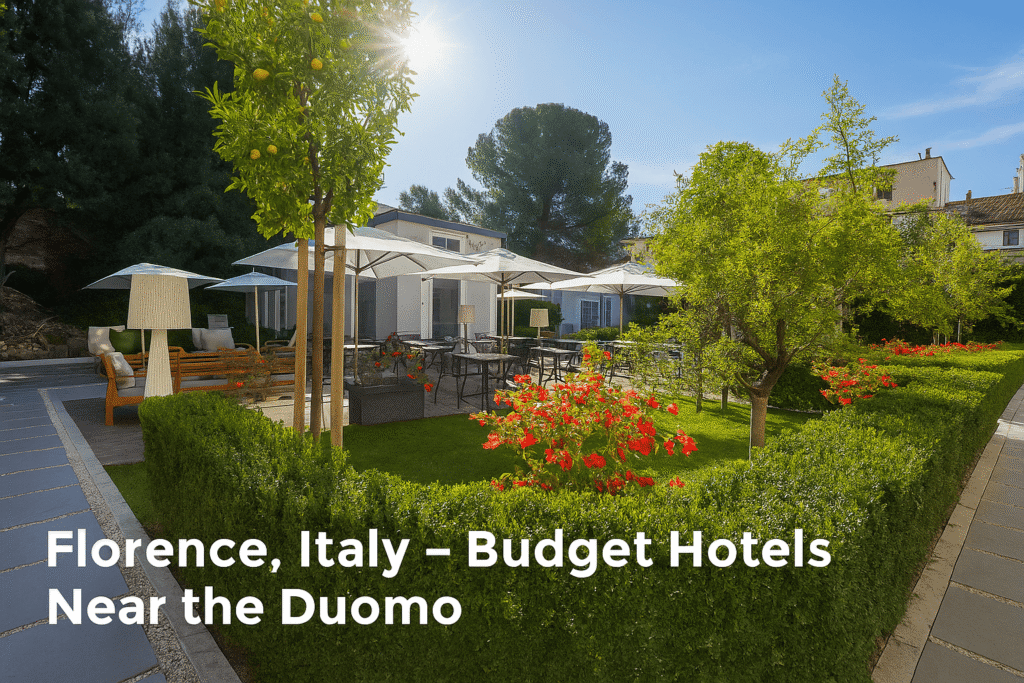 Beautiful garden patio at a budget hotel near the Duomo in Florence, Italy, featuring outdoor seating, umbrellas, green hedges, and blooming red flowers under a sunny sky.